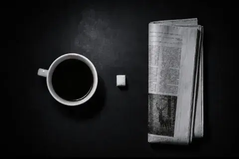 Une tasse de café un sucre un journal