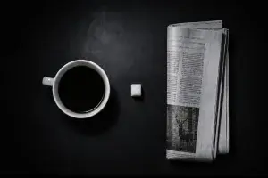 Une tasse de café un sucre un journal